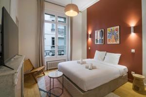 パリにあるCharme et standing - 2 chambres proches Trocadéroの大きな白いベッドと窓のある寝室