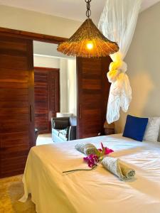a bedroom with a white bed with a chandelier at Wind Village in Itarema