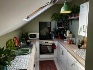a small kitchen with white cabinets and a sink at 8b The Bookcase in Dawlish
