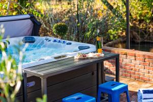a hot tub with a table and a bottle of wine at Sonoma Creek Haven in Kenwood