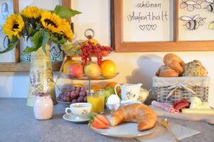 uma mesa de pequeno-almoço com croissants pão e ovos e um vaso de flores em B&B Friedau em Nottwil