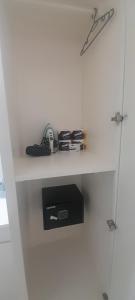 eine weiße Wand mit einem Regal mit Gegenständen darauf in der Unterkunft Ocean Bliss Apt 6 in Christchurch