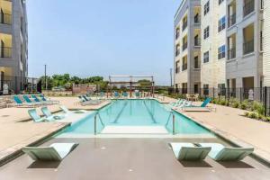 einen Pool mit Liegestühlen in einem Gebäude in der Unterkunft Modern 2br Pet-friendly Wd Pool&gym Utsa in San Antonio