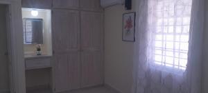 ein weißer Raum mit einem Fenster, einem Waschbecken und einer Tür in der Unterkunft Ocean Bliss Apt 6 in Christchurch + 22 Fotos