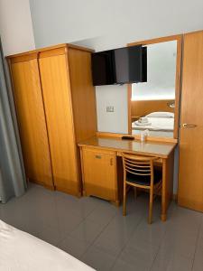 a room with a desk with a television and a bed at Hotel Garden Bologna in Crespellano