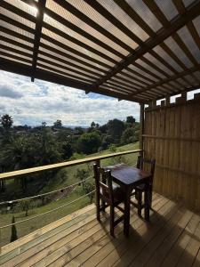 a table and chairs on a deck with a view at Alto Paraiso Glamping "A" in Carmen de Viboral