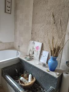 ein Badezimmer mit Badewanne, einem Korb und einer Vase in der Unterkunft 3B Firenze in Capraia e Limite