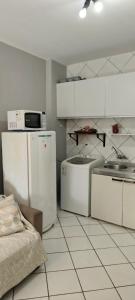a kitchen with white cabinets and a sink and a refrigerator at Studio Centro Floripa 02 in Florianópolis +12 photos