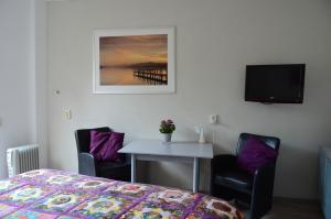 a bedroom with a bed and a table with two chairs at Eindhoven 2 Sleep in Eindhoven