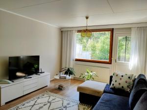 a living room with a tv and a blue couch at Rivitalokaksio, Kinnula in Kinnula