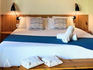 a bed with two pairs of slippers on it at Quattuor Cabanas Pousada in São Miguel do Gostoso