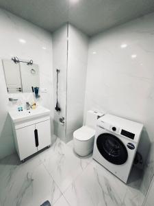 a white bathroom with a toilet and a washing machine at Alvina complex Vakas Tsakghadzor apartament in Tsaghkadzor +6 photos