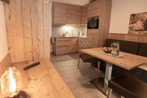 una cucina con un tavolo di legno e una sala da pranzo di Senner Appartements a Umhausen