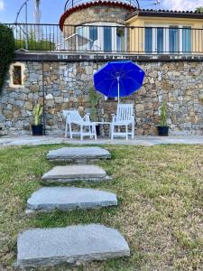 a patio with a table and an umbrella and chairs at Mare e Relax - Il Villino ai Tre Ponti - Monolocale in Sanremo +49 photos