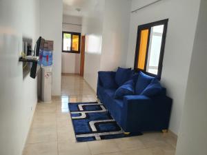 ein Wohnzimmer mit einem blauen Sofa und einem Teppich in der Unterkunft Sicap baobab , Mermoz, Sacré Coeur , Clim, Wifi, Balcon, Dakar in Grand Dakar