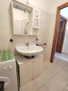 a bathroom with a sink and a mirror at Appartamento Sterlizia in Porto Alabe