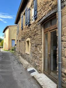 un antiguo edificio de piedra con una puerta en una calle en Appartement plein coeur village, en Étoile-sur-Rhône