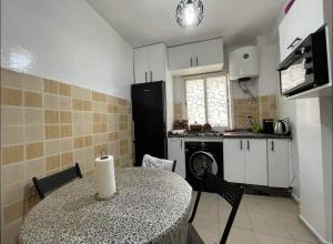 a kitchen with a table and a kitchen with a refrigerator at Sweet Home in El Jadida