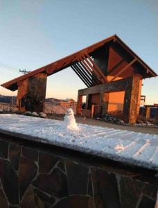 Un muñeco de nieve está parado frente a un edificio. en Casa do Vinho no Altos da Serra, en Bom Jardim da Serra