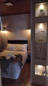 1 dormitorio con cama y estante con zapatos en Casa do Vinho no Altos da Serra, en Bom Jardim da Serra