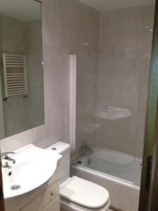 e bagno con lavandino, servizi igienici e vasca. di 44 Centro Apartaments & Suites a Madrid