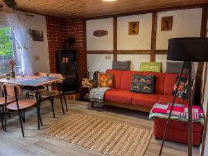 a living room with a red couch and a table at Ruheplatz in der Natur in Pansfelde