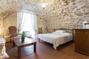 a bedroom with a bed and a table and a window at Nel cuore di Narni in Narni