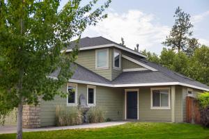 a house with green siding and a gray roof at Private Hot-Tub- 3 BDR for 8 Pet's OK in Bend