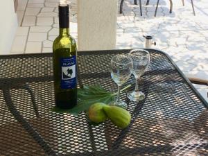 a bottle of wine and two glasses on a table at Villa Angel Dalia in Novi Vinodolski