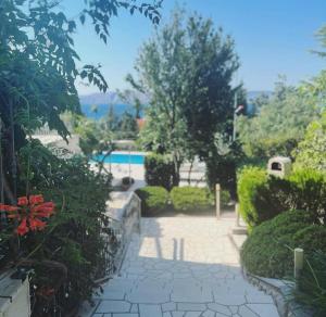 a garden with a walkway and a swimming pool at Villa Angel Dalia in Novi Vinodolski