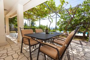 a patio with a black table and chairs at Villa Angel Dalia in Novi Vinodolski
