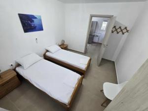 een kamer met 2 bedden en een koelkast bij uncie spiros house in Nea Fokea