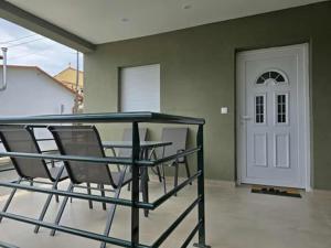 a balcony with two chairs and a white door at uncie spiros house in Nea Fokea
