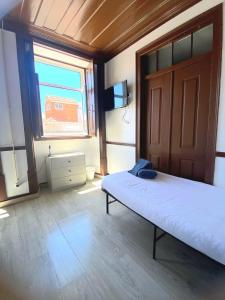 a bedroom with a bed and a large window at Private Room 204 in Guest House da Fonte in Figueira da Foz +9 photos