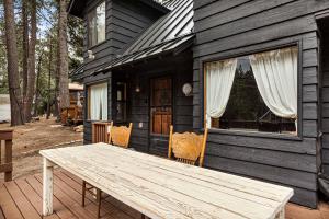 a wooden table in front of a house at Pineland Getaway - Serene Escape in Green Valley Lake