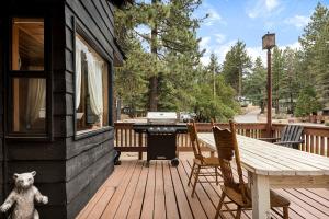 a teddy bear sitting on a deck with a grill at Pineland Getaway - Serene Escape in Green Valley Lake