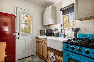 eine Küche mit einem blauen Herd und einer Mikrowelle in der Unterkunft Into the Woods Bungalow - Romantic Vacation in Big Bear Lake