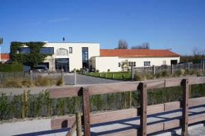 una valla de madera frente a un edificio en B&B Oesterhoeve, en Ostende