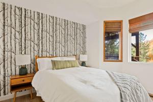 a bedroom with a bed and a wall with trees at The Fancy Fox - Stunning 4 BR Retreat Close to Lake in Lake Arrowhead