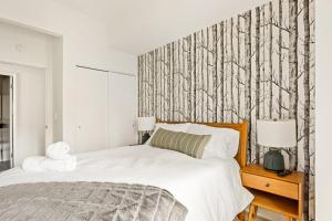 a bedroom with a bed and a wall with trees at The Fancy Fox - Stunning 4 BR Retreat Close to Lake in Lake Arrowhead +36 photos