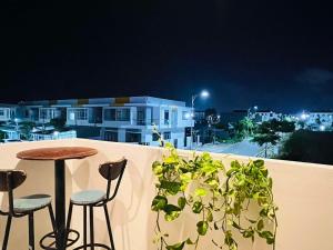 a table and two chairs on a balcony at night at KYNA house in Rạch Giá