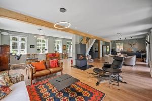 ein Wohnzimmer mit Couch und Kamin in der Unterkunft GUT KLETKAMP "Försterei" - Freistehendes Backsteinhaus mit 4 Schlafzimmern ruhig am Waldrand gelegen I Kamin I Garten & Terrasse I 15 Min zur Ostsee I 3 Bäder I Küche I Parkplatz I WLAN in Kletkamp