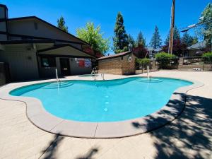una piscina en un patio con una casa en The Adler's Nest - Lakefront with Pool Spa and Summer Dock, en Big Bear Lake