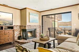 Una sala de estar con un sofá y una chimenea. en The Adler's Nest - Lakefront with Pool Spa and Summer Dock, en Big Bear Lake