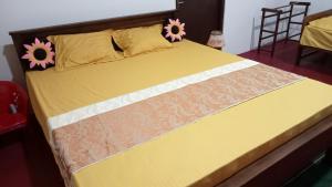 a yellow bed with flowers on top of it at New Look villa in Mirissa +7 photos