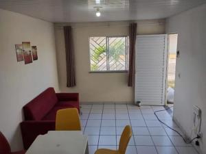 a living room with a red couch and a window at Casa Tracoá 2 in Arunta