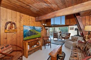 a living room with wood paneled walls and a television at Yosemite Pines Cabin - Sleeps 6 in Big Bear Lake