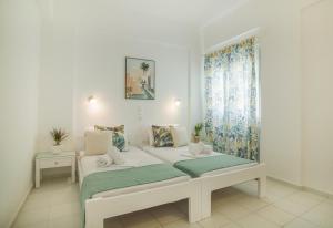 a white room with a bed and a window at AquaMarine Suites A in Kokkíni Khánion