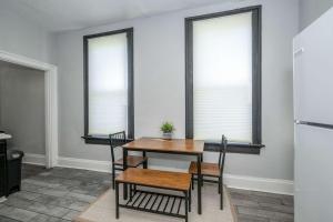 een eetkamer met een tafel en stoelen en 2 ramen bij Chic Modern Gem with Style in Cincinnati