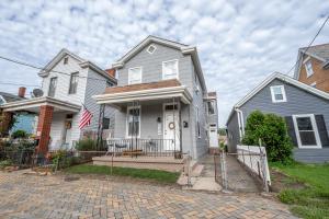 a white house with a flag on the front of it at Historic Ludlow Suites - 2 Apts in Ludlow